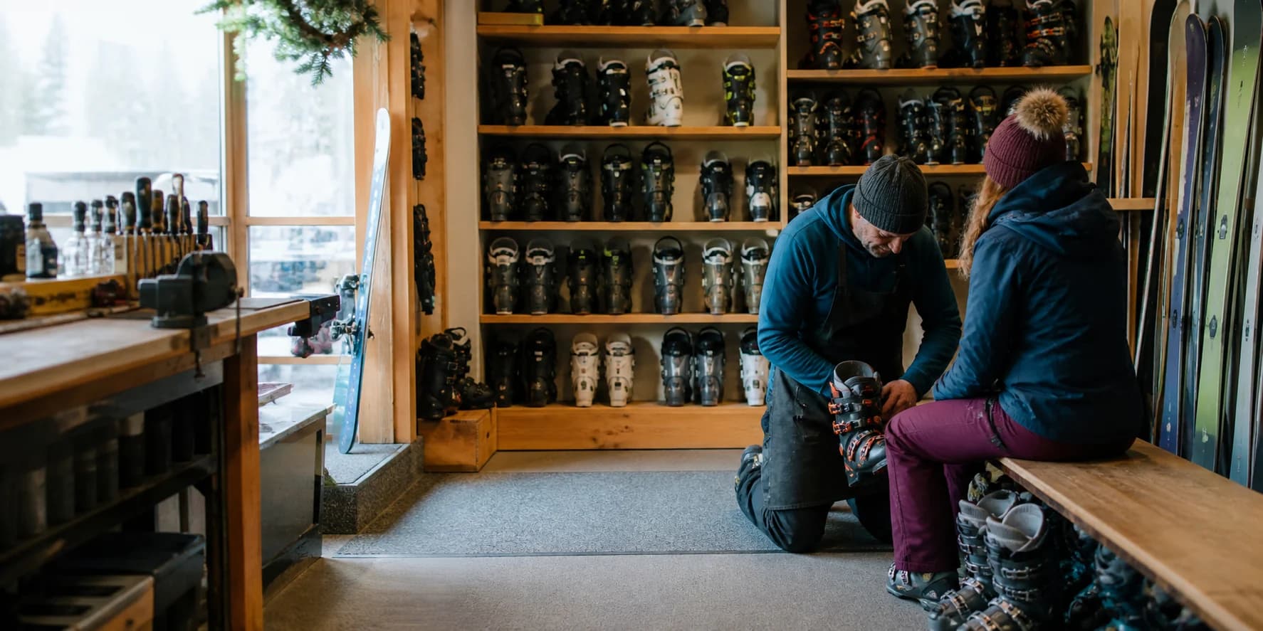 Ski technician helping a customer fit alpine ski boots