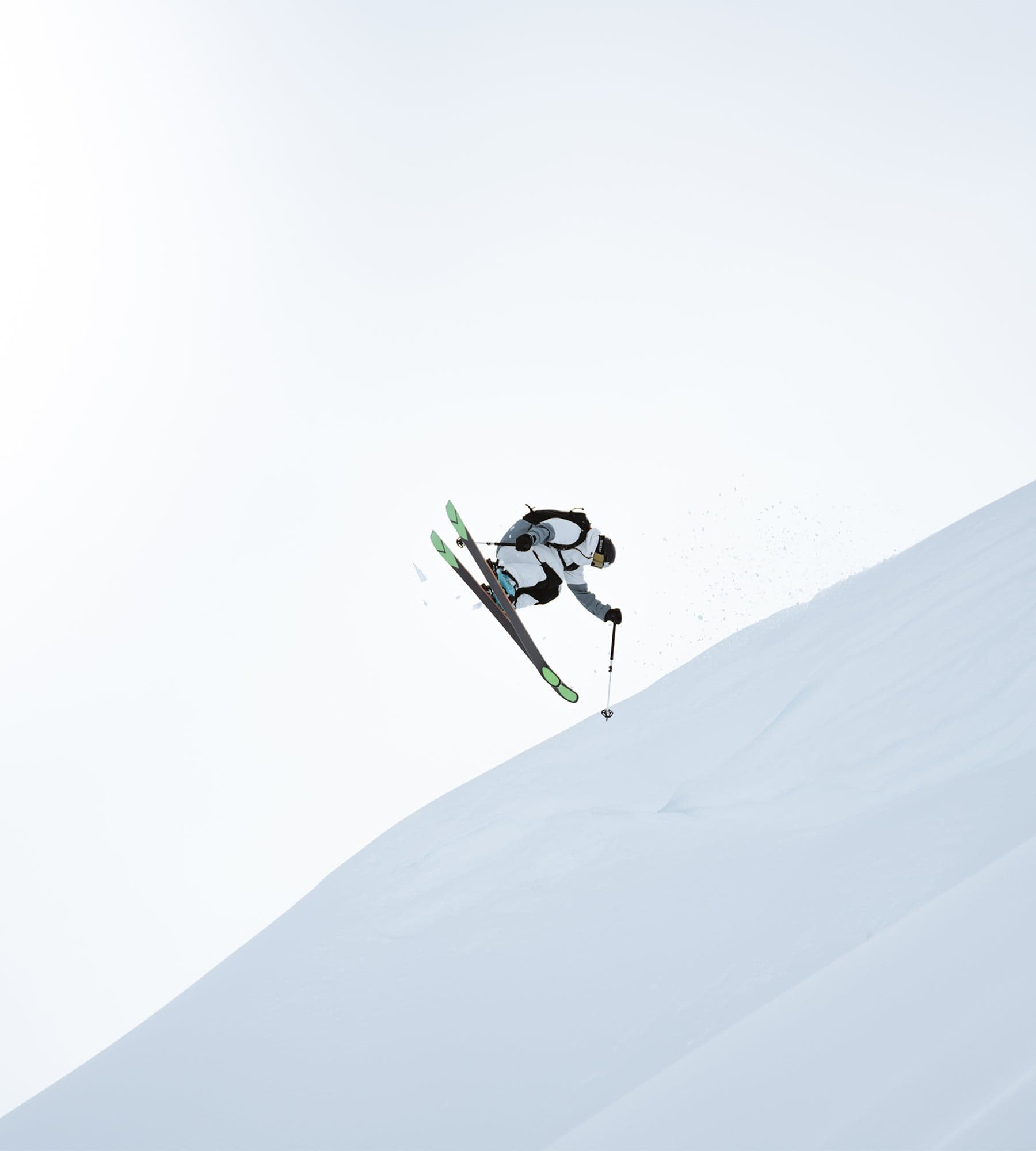 Freeride skier floating above a snow-covered ridge on Kästle skis